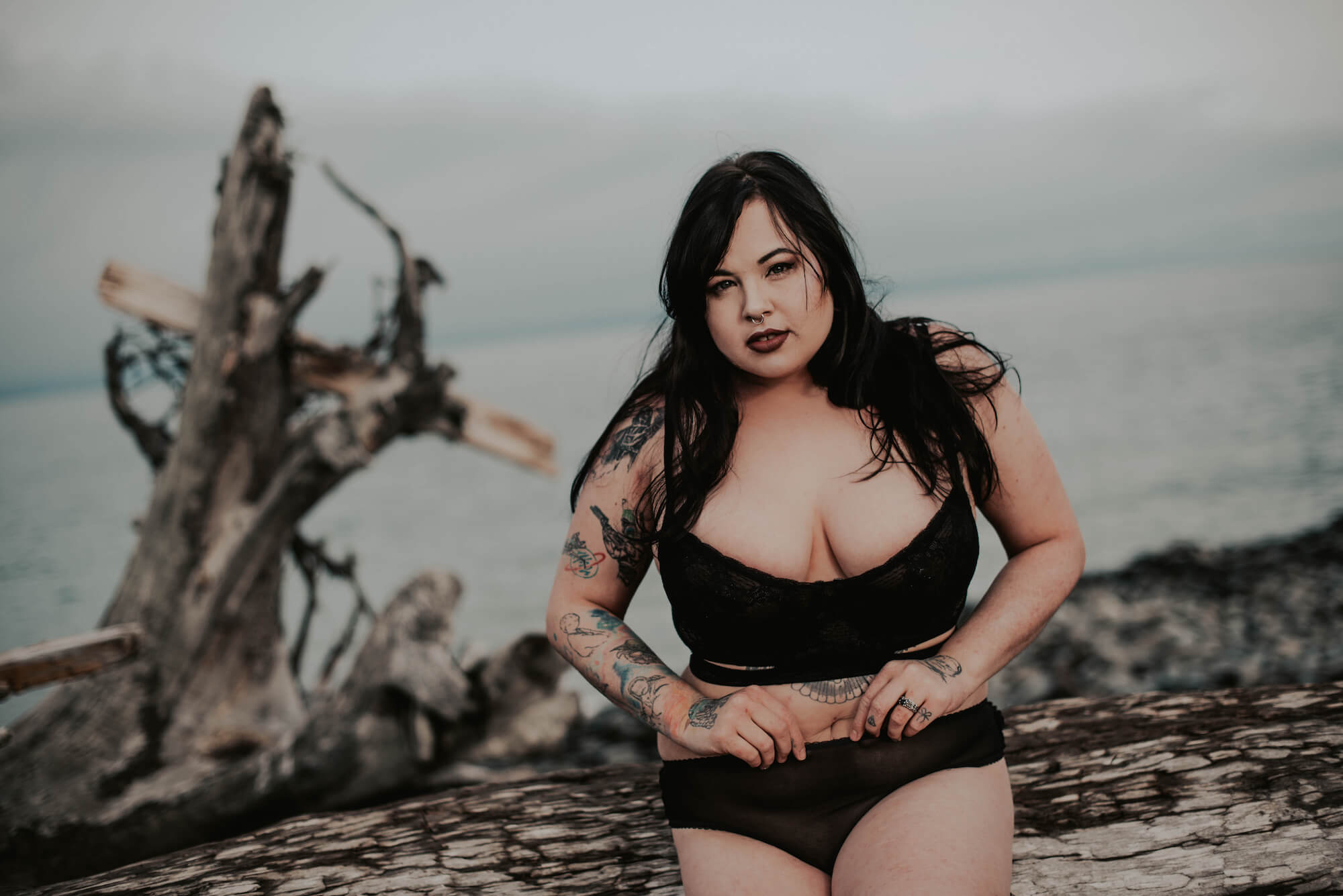 woman sitting on drift wood for her port angeles boudoir session