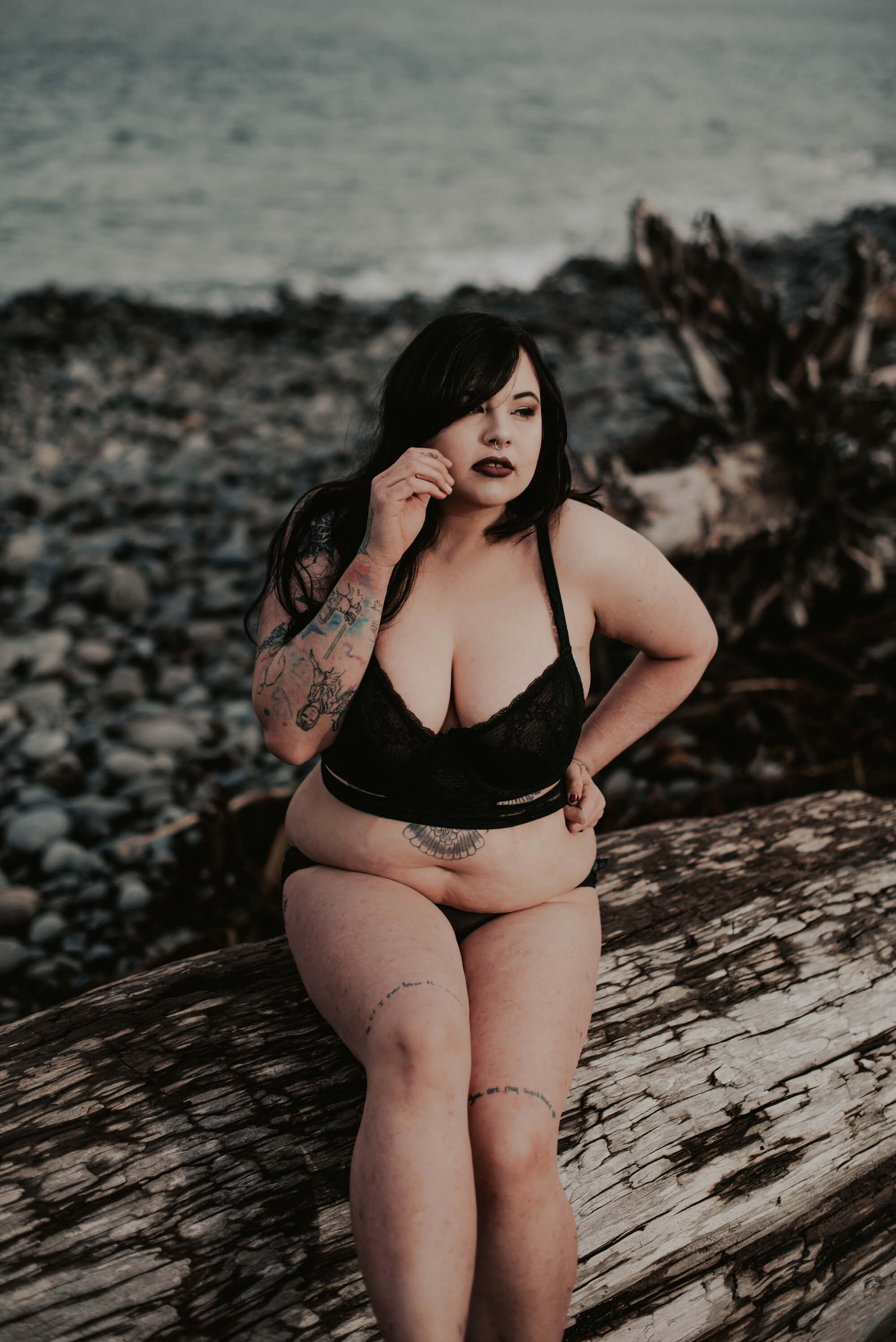 tattooed woman posing outdoor in black lingerie 