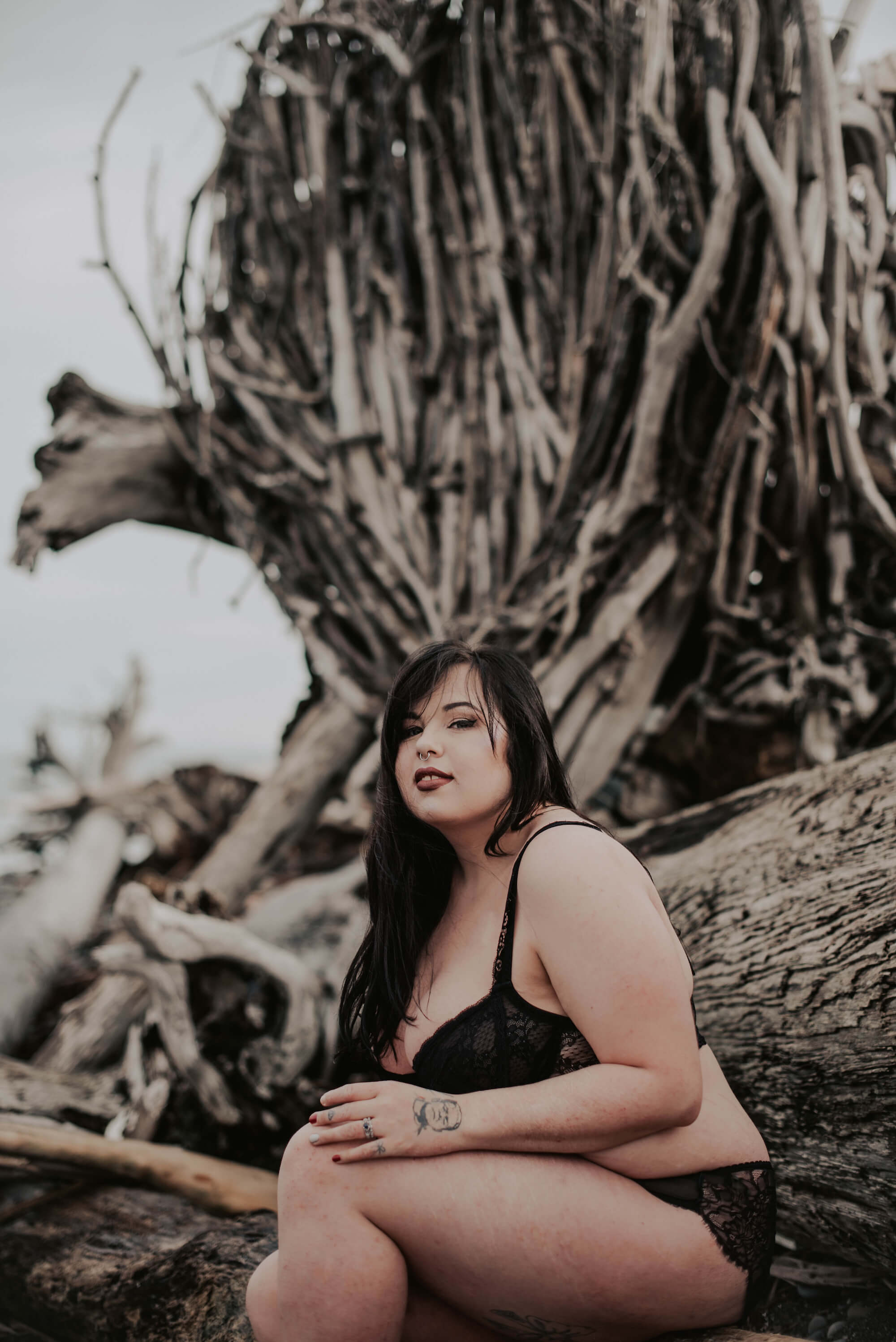woman posing on driftwood in port angeles Washington 