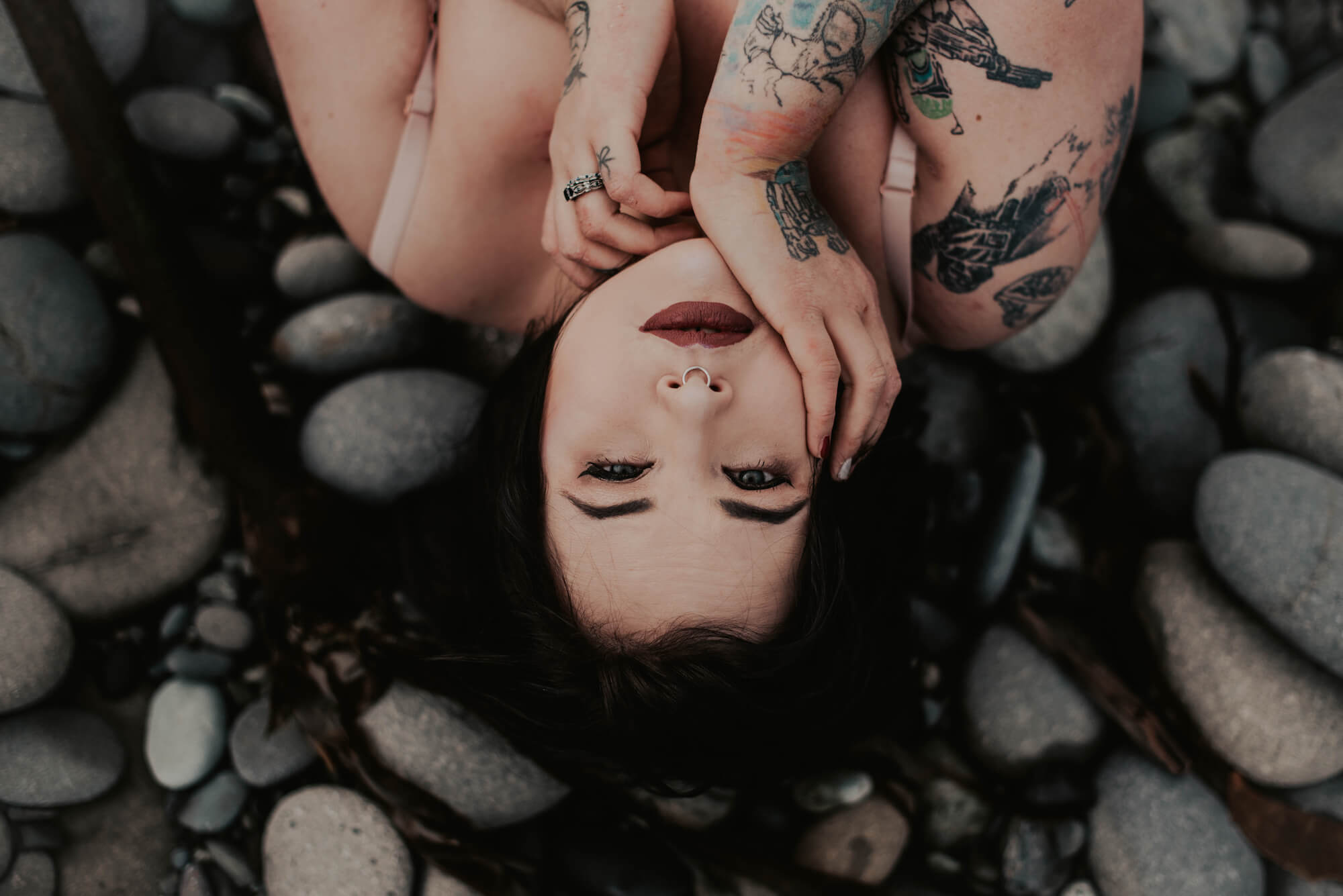 woman lying on rock on cold PNW beach