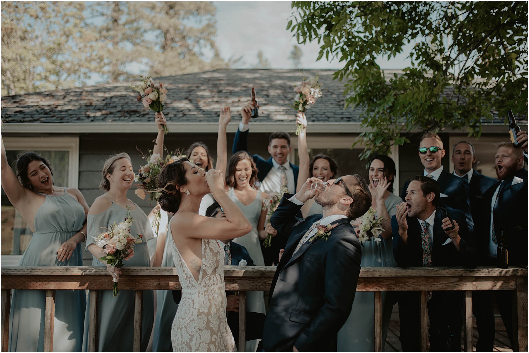 bride and groom taking a shot, bridal party cheering couple on