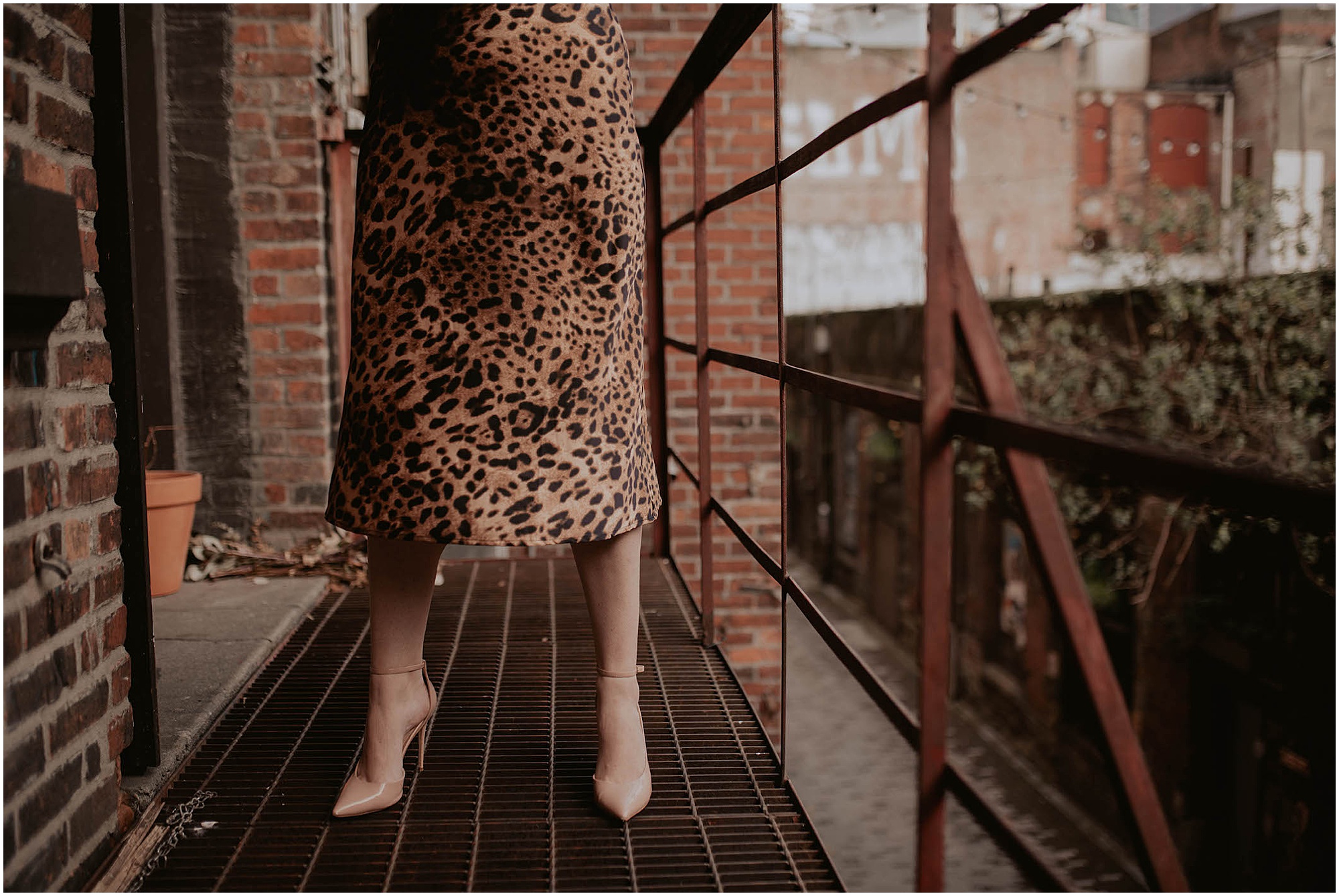 leopard print skirt, woman in heels on fire escape