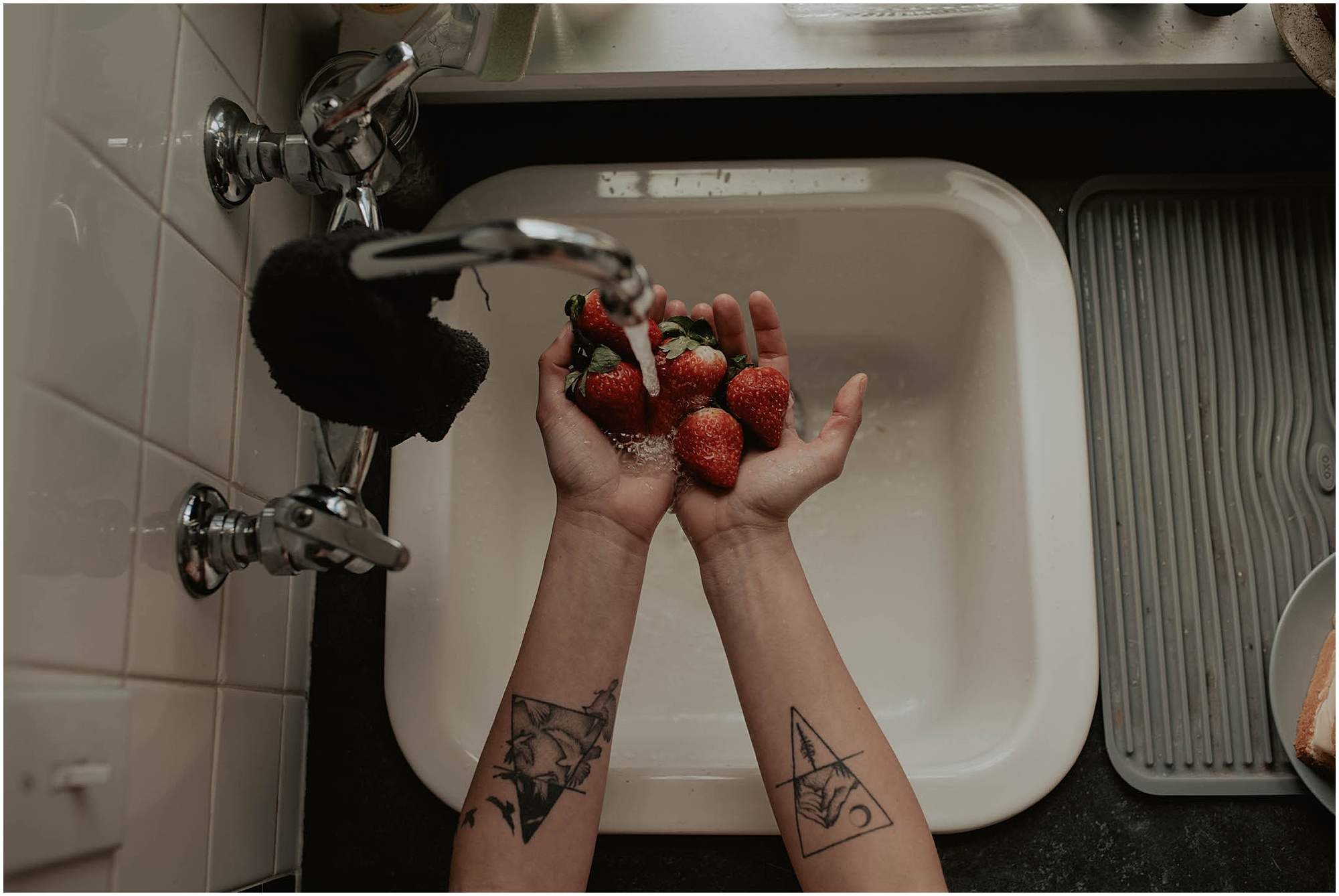 strawberries in hand over kitchen sink, departing seattle 