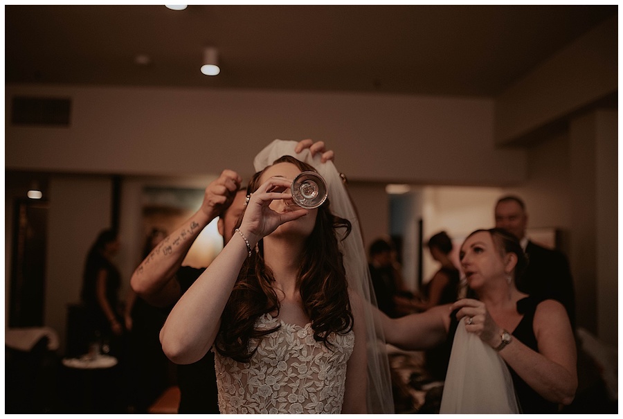 bride chugging champagne before leaving hotel on wedding day