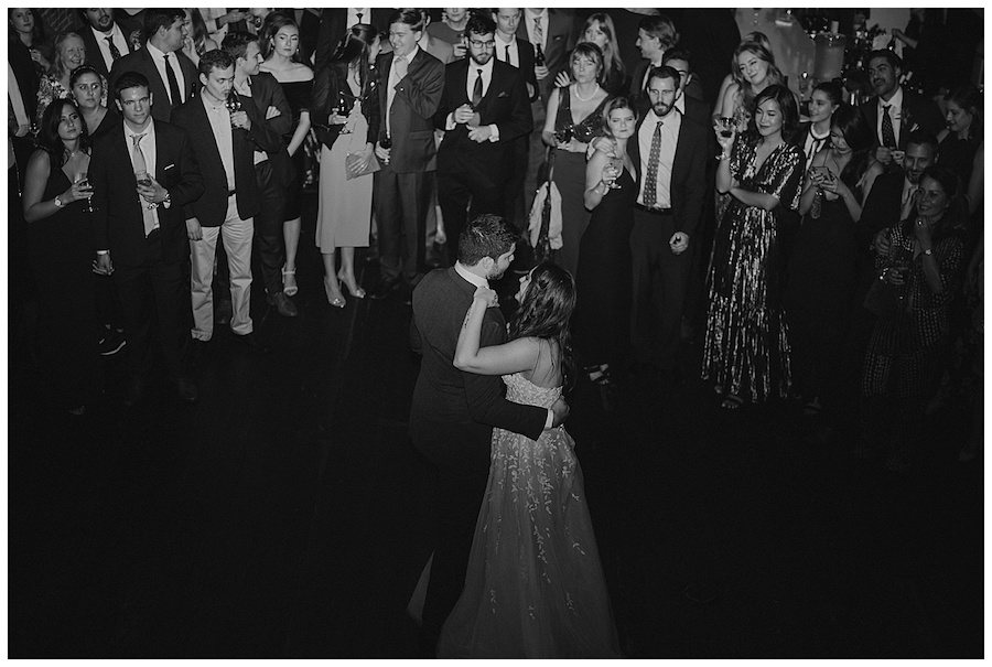 wedding guests gathered around bride and groom for first dance at axis pioneer square