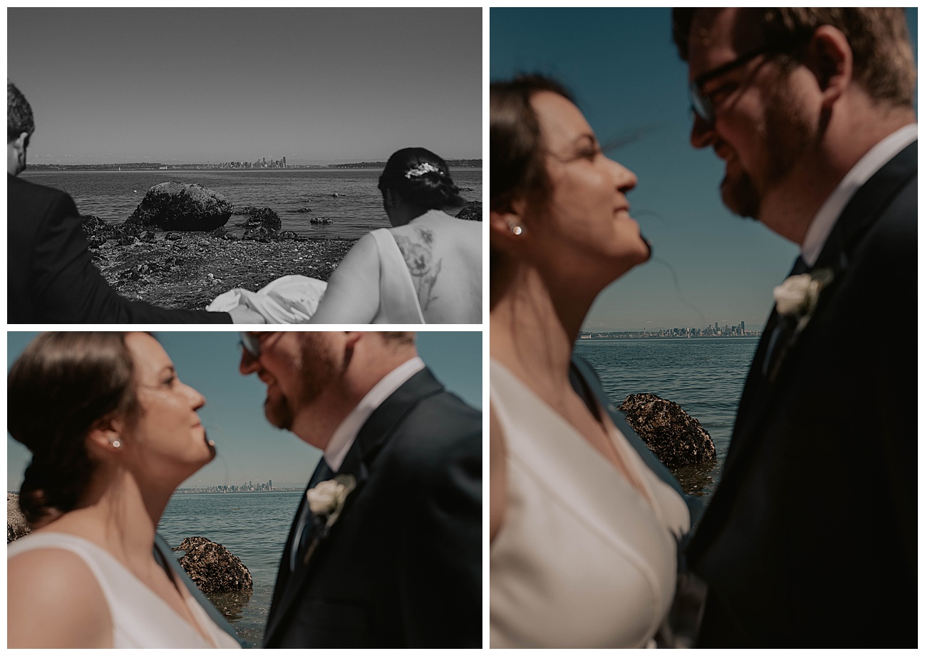 bride and groom standing on beach with seattle skyline in the background 