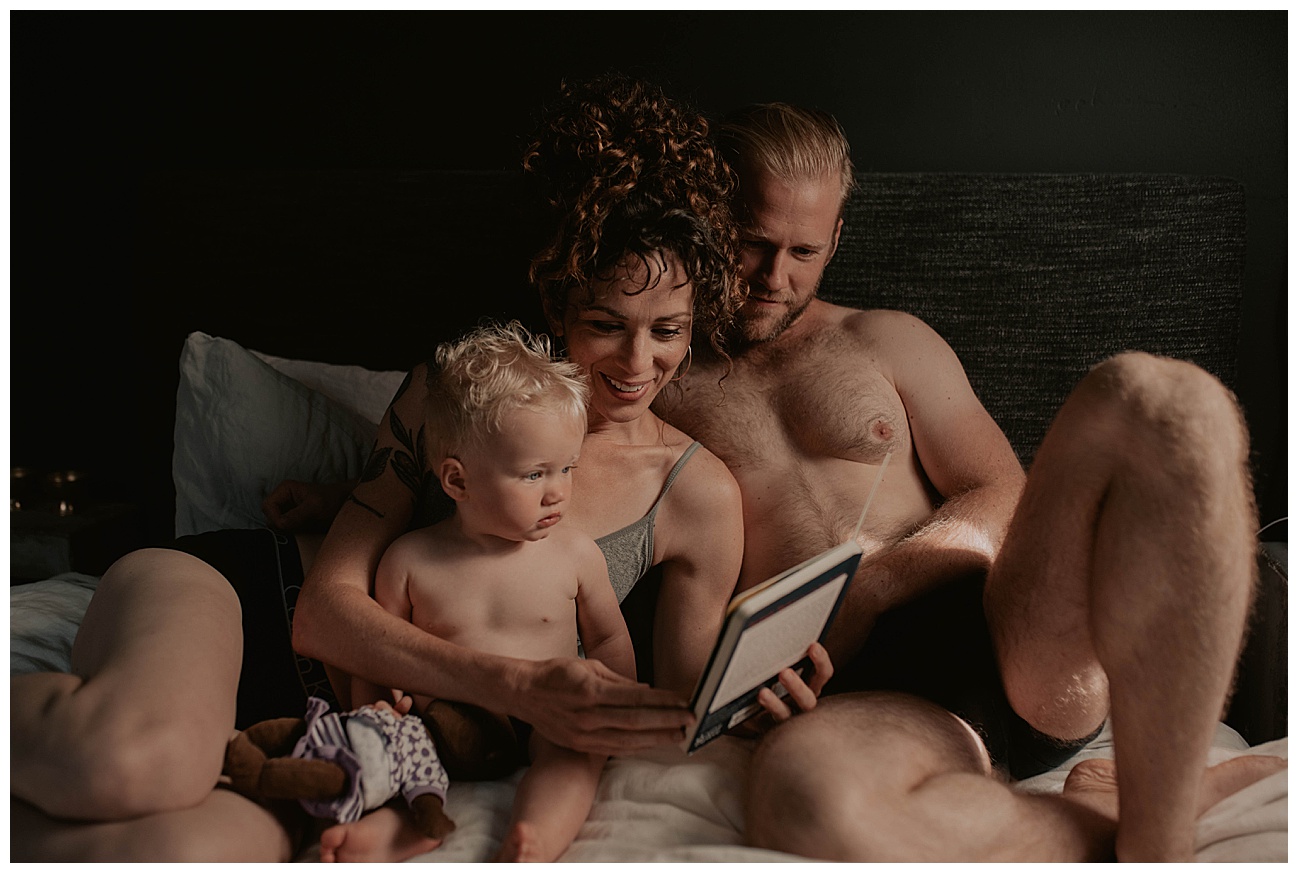 family in bed reading to their child