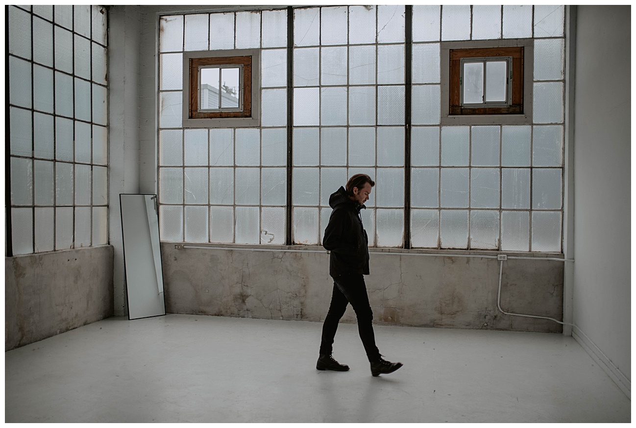 man walking in studio with loft style windows downtown seattle