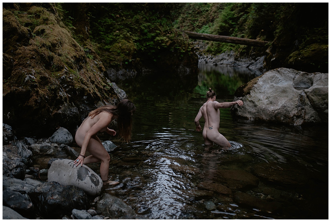 naked couple walking into the river in PNW