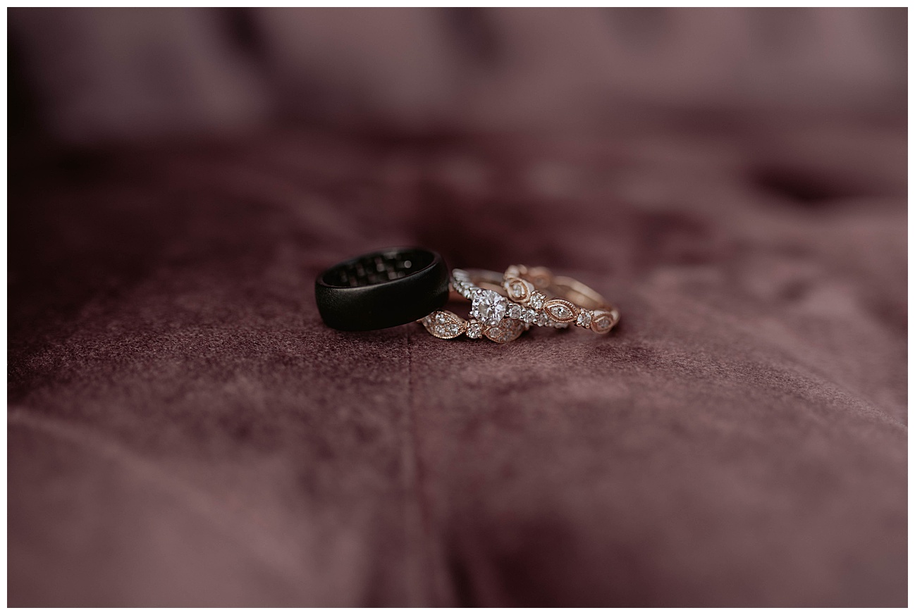 bride and grooms wedding rings on purple velvet couch 