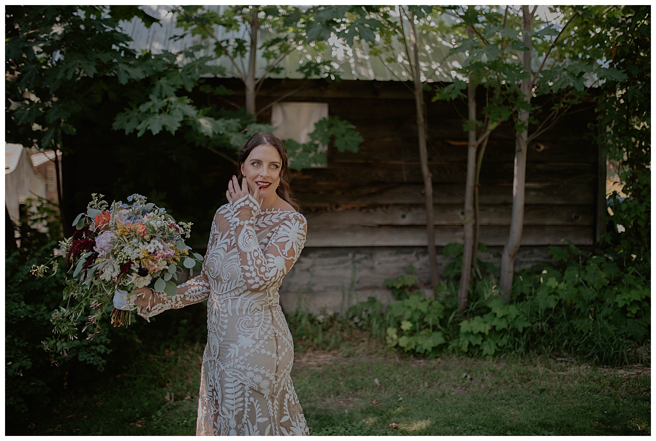 bride holding large bouquet in bohemian wedding dress