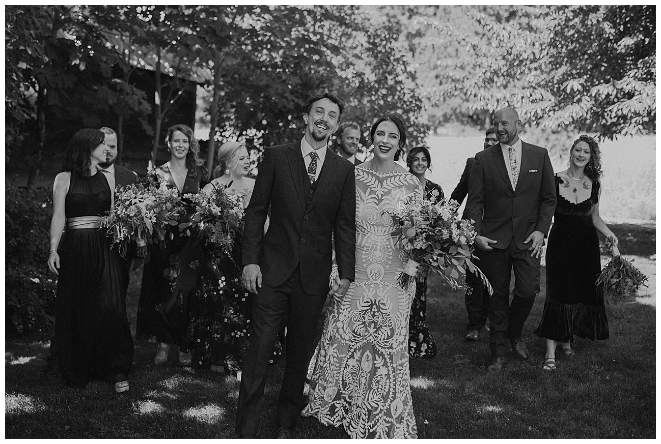 bride and groom walking with their bridal party behind them