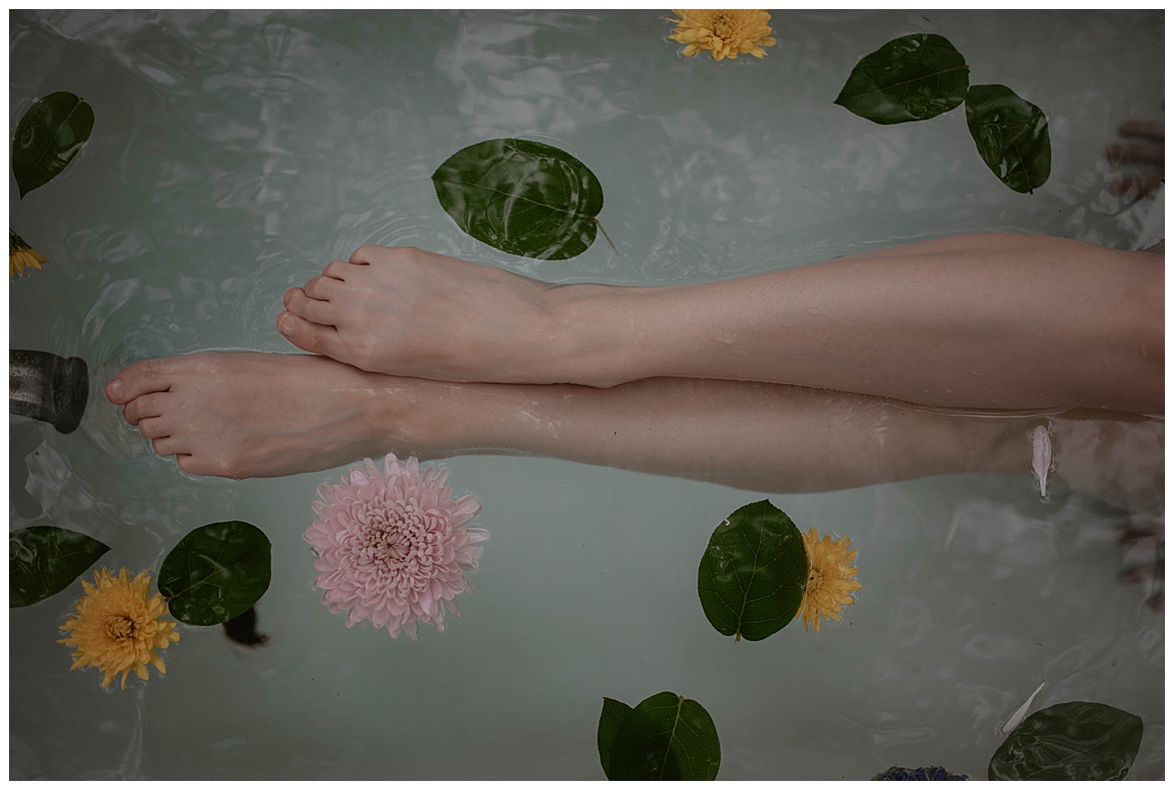 Tatted woman, outdoor clawfoot bathtub, outdoor boudoir, bath boudoir, flowers in water, legs in water